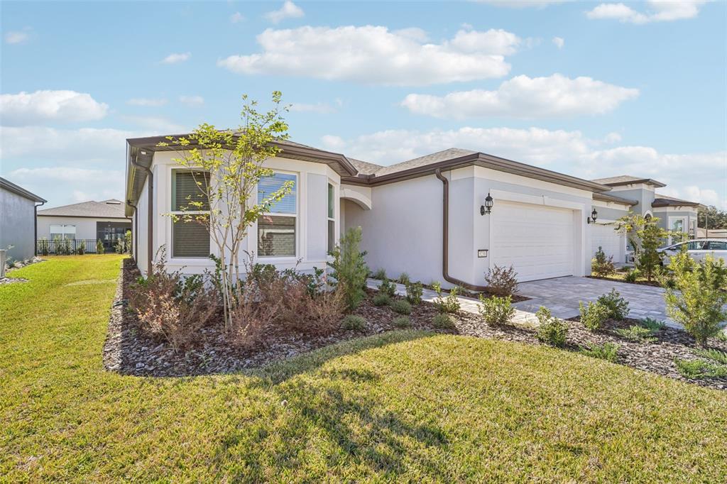 A single-story house with a white stucco exterior, a two-car garage, and a landscaped yard — 5236 SW 88TH CIRCLE, OCALA, FL
