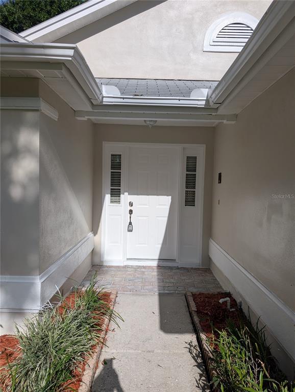 The exterior entryway features a white front door with sidelights and a paved porch — 4205 BARRET AVENUE, PLANT CITY, FL