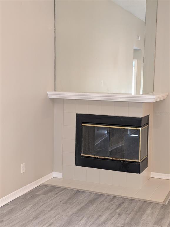 A corner fireplace with a tiled surround and a large mirror above the mantel — 4205 BARRET AVENUE, PLANT CITY, FL