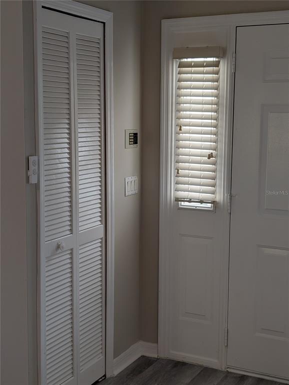 A white louvered closet door sits next to a white entry door with blinds — 4205 BARRET AVENUE, PLANT CITY, FL