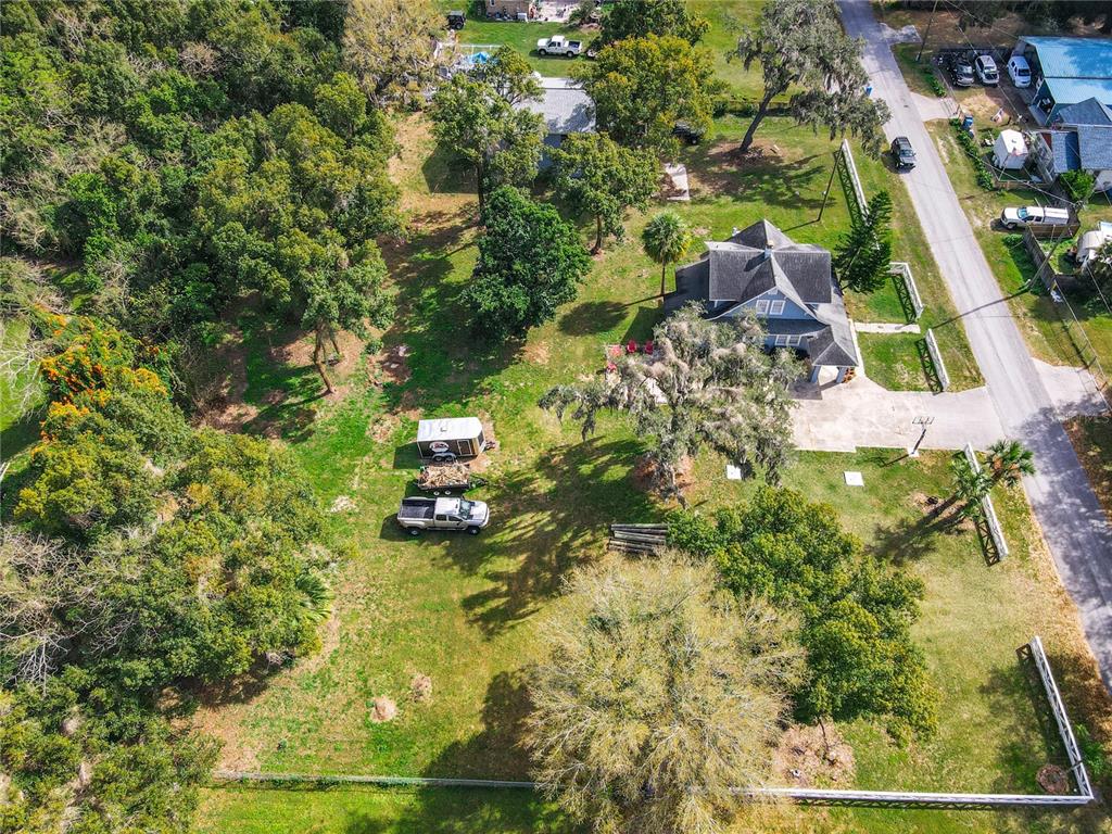 An aerial view shows a house with a large yard, trees, and a parked truck — TIGHE STREET, SEFFNER, FL