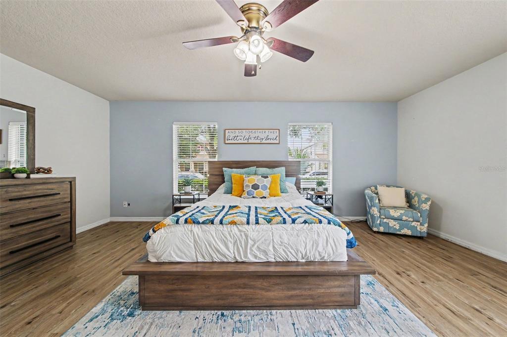 A bedroom features a wooden platform bed, light blue walls, wood-look flooring, and a ceiling fan — 13626 PHOENIX, ORLANDO, FL