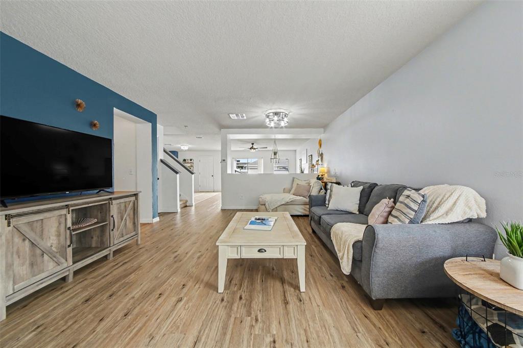 A living room features wood-look flooring, a blue accent wall, and a gray sofa — 13626 PHOENIX, ORLANDO, FL