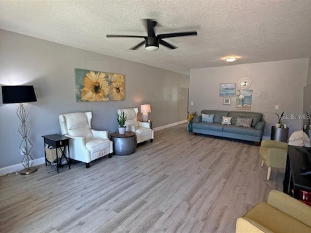 An empty living room with light wood-look flooring, gray walls, and a ceiling fan — 2262 SWEDISH DRIVE UNIT 14, CLEARWATER, FL