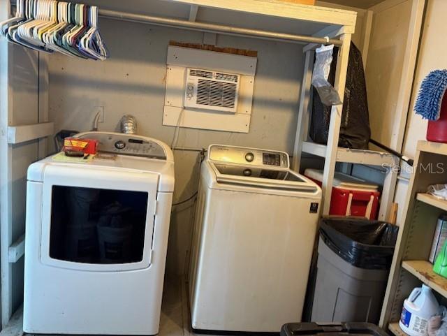 A laundry area features a white dryer and washing machine beneath a wall-mounted air conditioner — 29218 HECKLEMAN STREET, BROOKSVILLE, FL