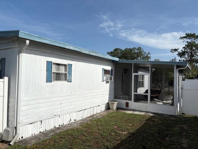 The exterior of a white mobile home features a screened-in porch and blue window shutters — 29218 HECKLEMAN STREET, BROOKSVILLE, FL