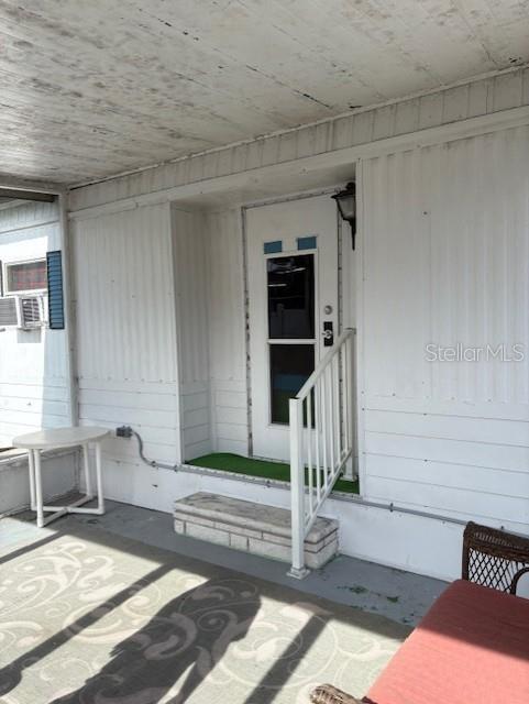 A white exterior door with a storm door opens onto a covered porch area — 29218 HECKLEMAN STREET, BROOKSVILLE, FL