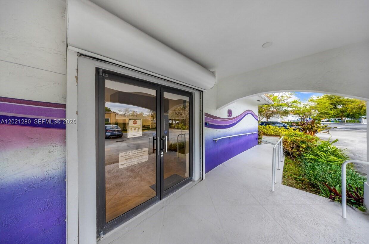 A glass double door entrance with a purple accent wall and a concrete walkway outside — 99 W 49th St, Hialeah FL 33012, HIALEAH, FL