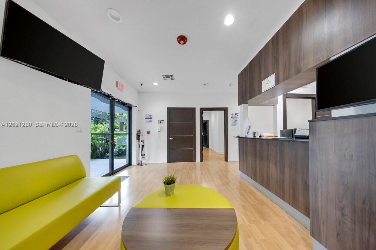 A waiting room features a lime green sofa, a matching coffee table, and a reception desk — 99 W 49th St, Hialeah FL 33012, HIALEAH, FL