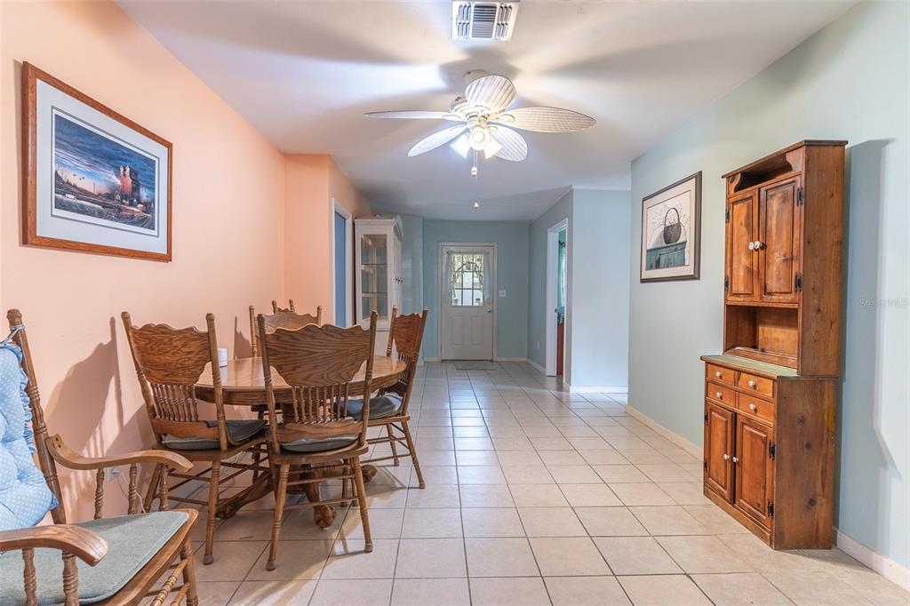 A dining room with tile floors, a wooden table set, and a hutch against a wall — 1645 HUNTINGTON STREET, LAKELAND, FL