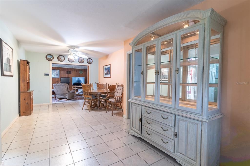 A dining area with tile floors, a large hutch, and a view into a living room — 1645 HUNTINGTON STREET, LAKELAND, FL