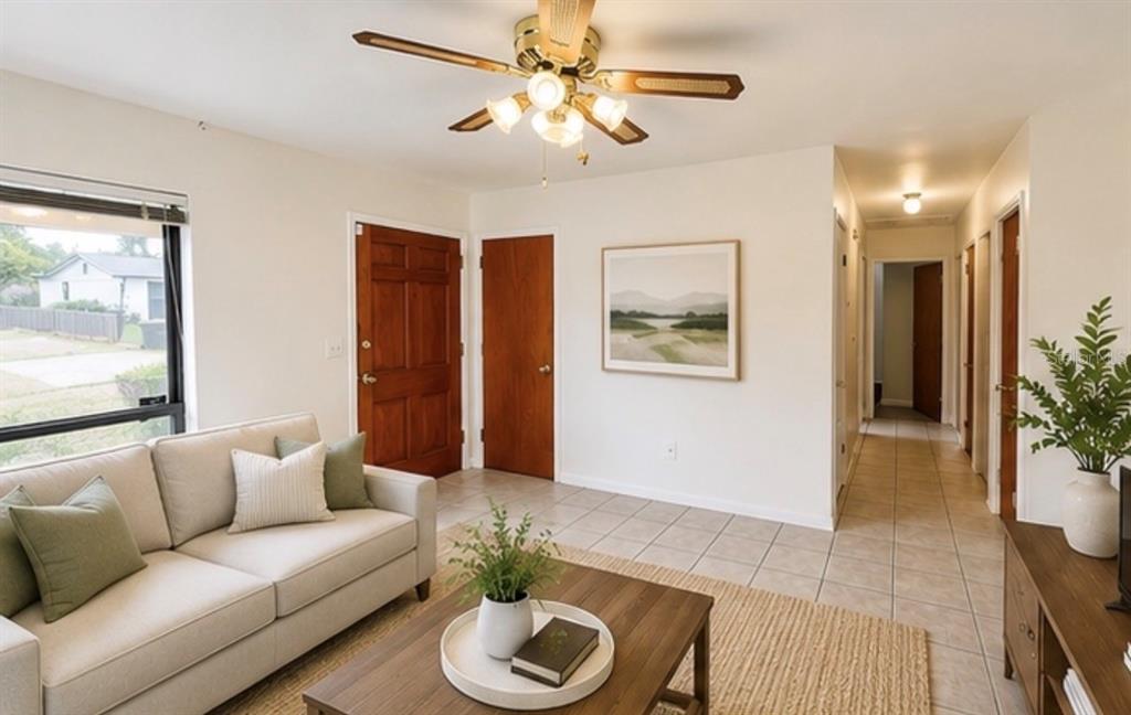 A living room features a beige sofa, wooden coffee table, tile floors, and a ceiling fan — 7310 FILBERT LANE, TAMPA, FL
