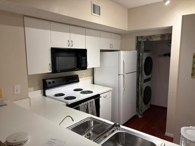A kitchen features white cabinets, a black microwave, a white stove, and a white refrigerator — 1590 S 42nd Circle S # 308, Vero Beach FL 32967, VERO BEACH, FL