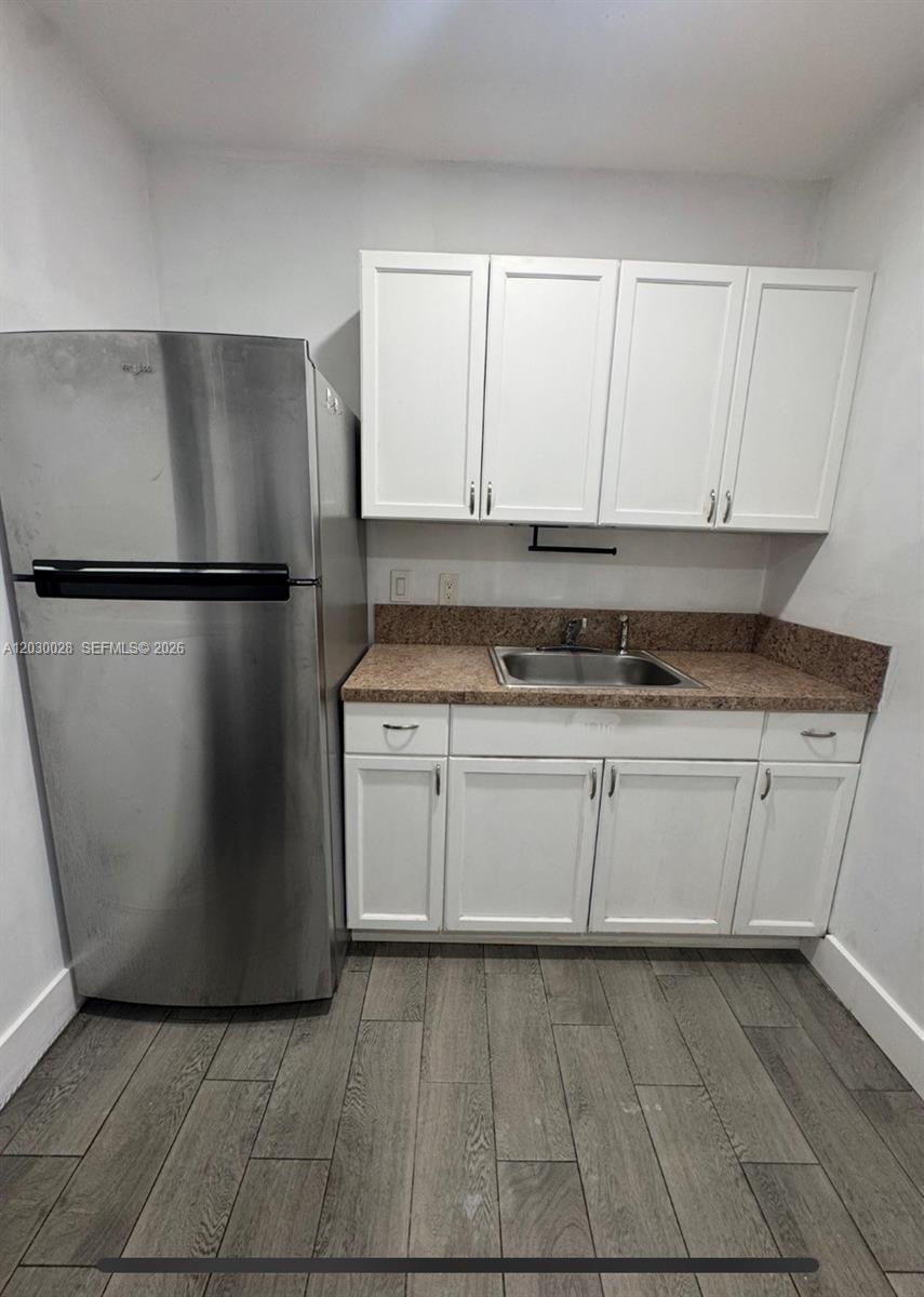 A small kitchen features white cabinets, a stainless steel refrigerator, and a brown countertop — 5860 NW 193rd St # 1, Hialeah FL 33015, HIALEAH, FL
