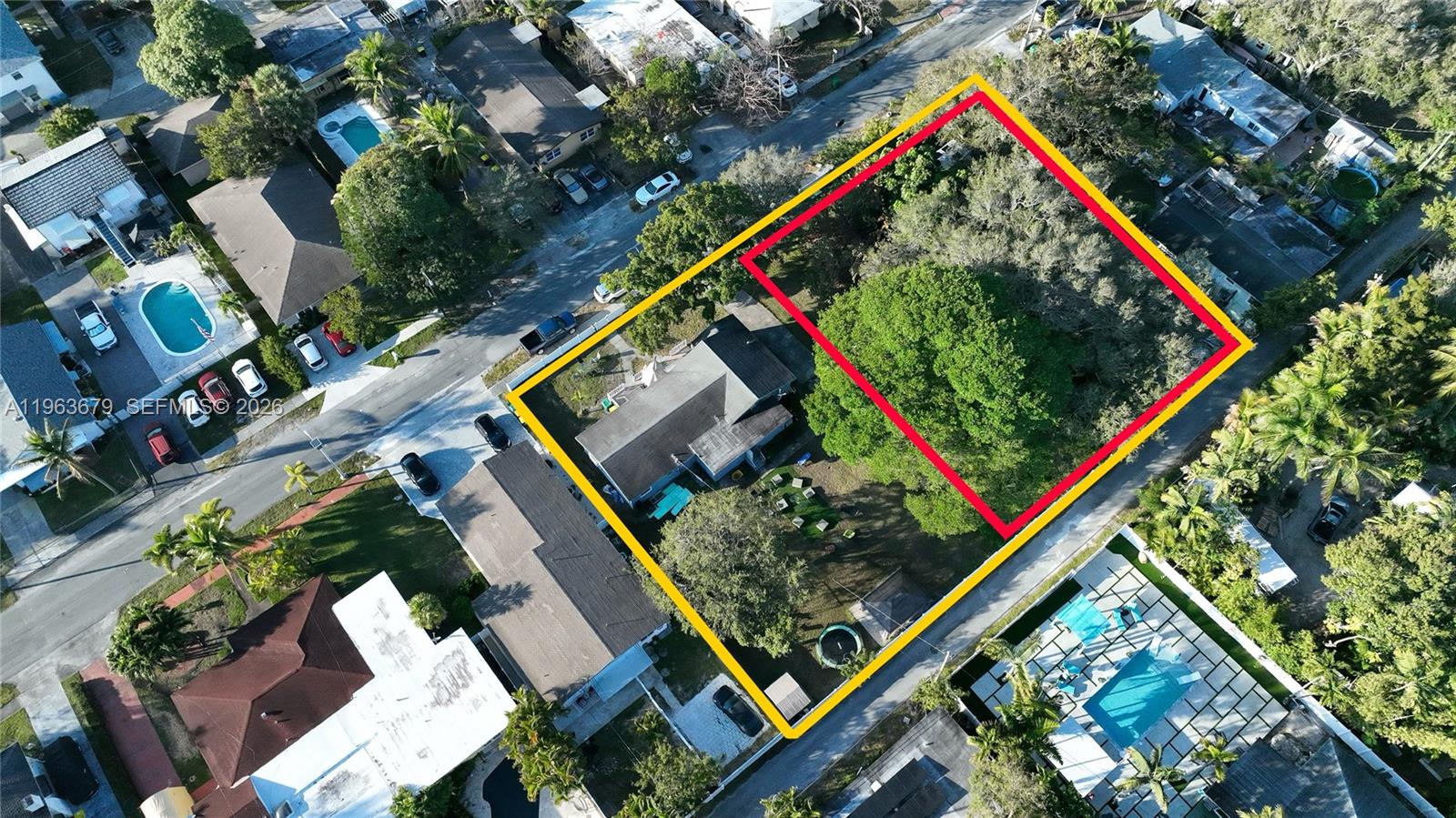 An aerial view shows a light blue house with a driveway and surrounding trees — 228 SW 8th St, Dania Beach FL 33004, DANIA BEACH, FL
