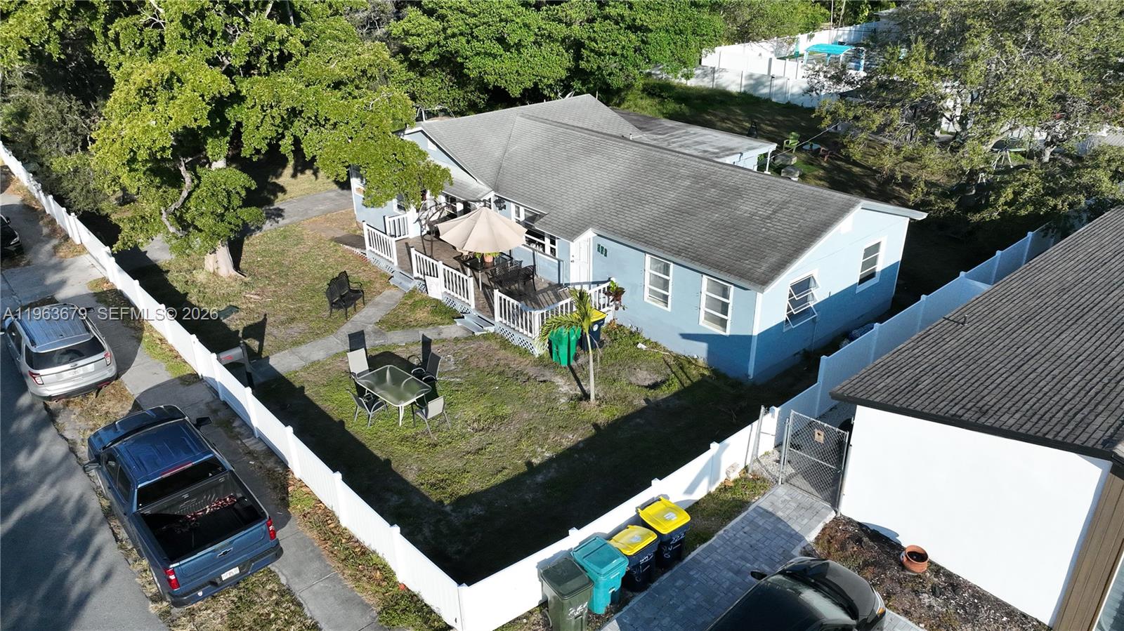 An aerial view shows a light blue house with a deck and fenced yard — 228 SW 8th St, Dania Beach FL 33004, DANIA BEACH, FL