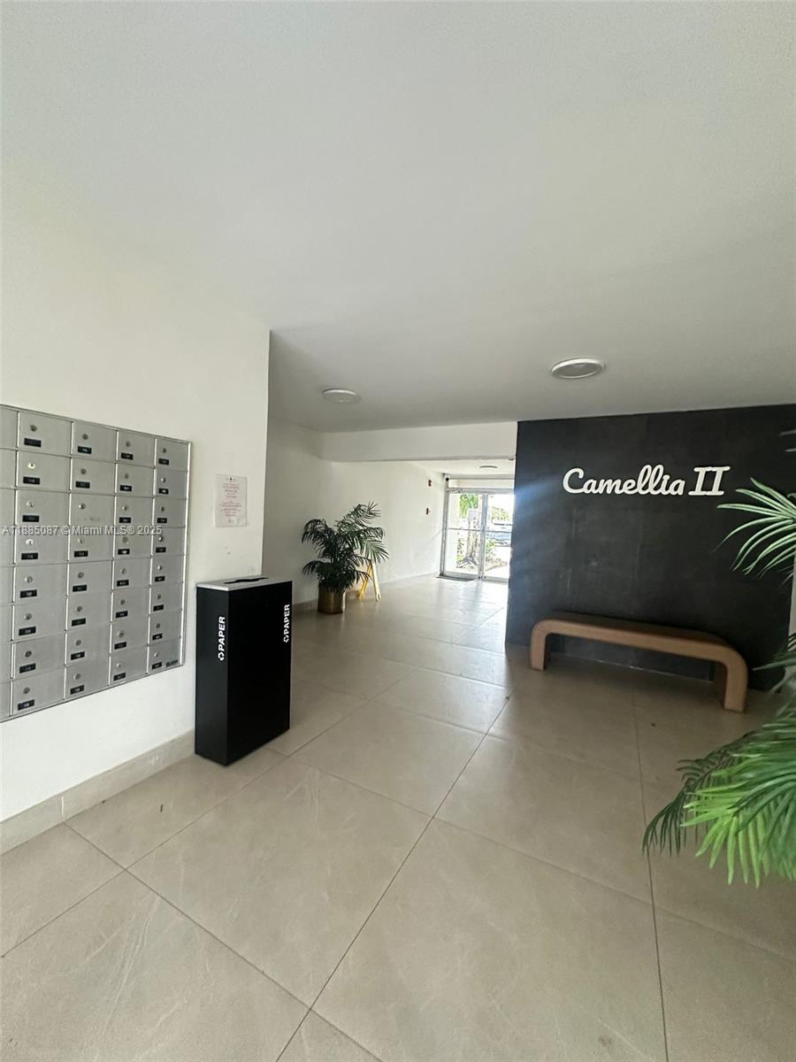 A residential building lobby features a wall of mailboxes, a paper recycling bin, and seating — 1780 NE 191st St # 2, Miami FL 33179, MIAMI, FL