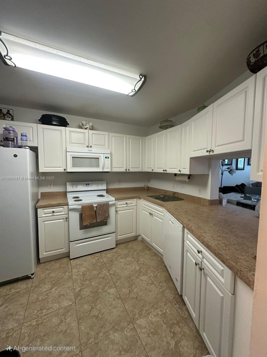 A kitchen features white cabinets, tan countertops, white appliances, and light-colored tile flooring — 1780 NE 191st St # 2, Miami FL 33179, MIAMI, FL