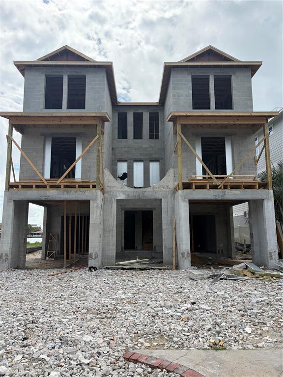 A two-story concrete residential building under construction with open framing and a gravel yard — 1213 BAY SHORE BOULEVARD, INDIAN ROCKS BEACH, FL