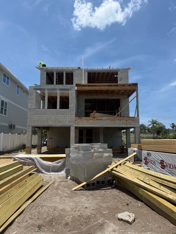 A multi-story concrete block residential structure under construction with stacks of lumber in the foreground — 1213 BAY SHORE BOULEVARD, INDIAN ROCKS BEACH, FL