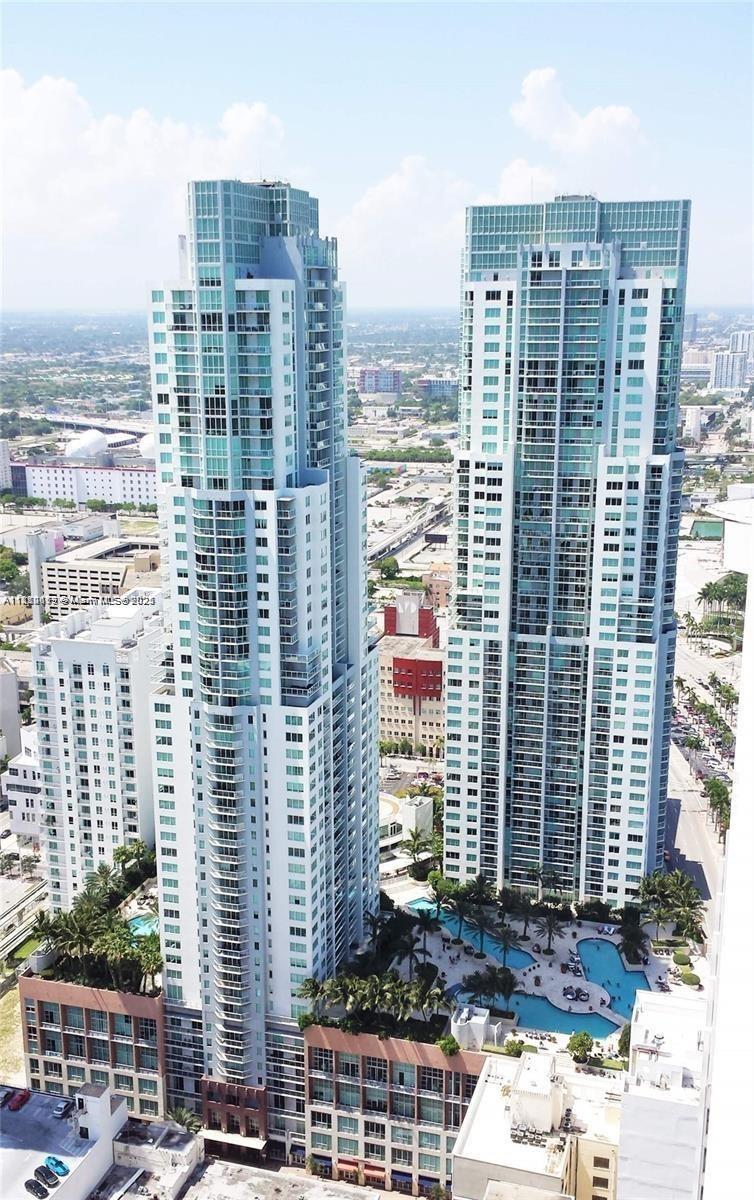 An aerial view shows two tall, modern glass residential towers with a shared swimming pool deck — 244 Biscayne Blvd # 643, Miami FL 33132, MIAMI, FL