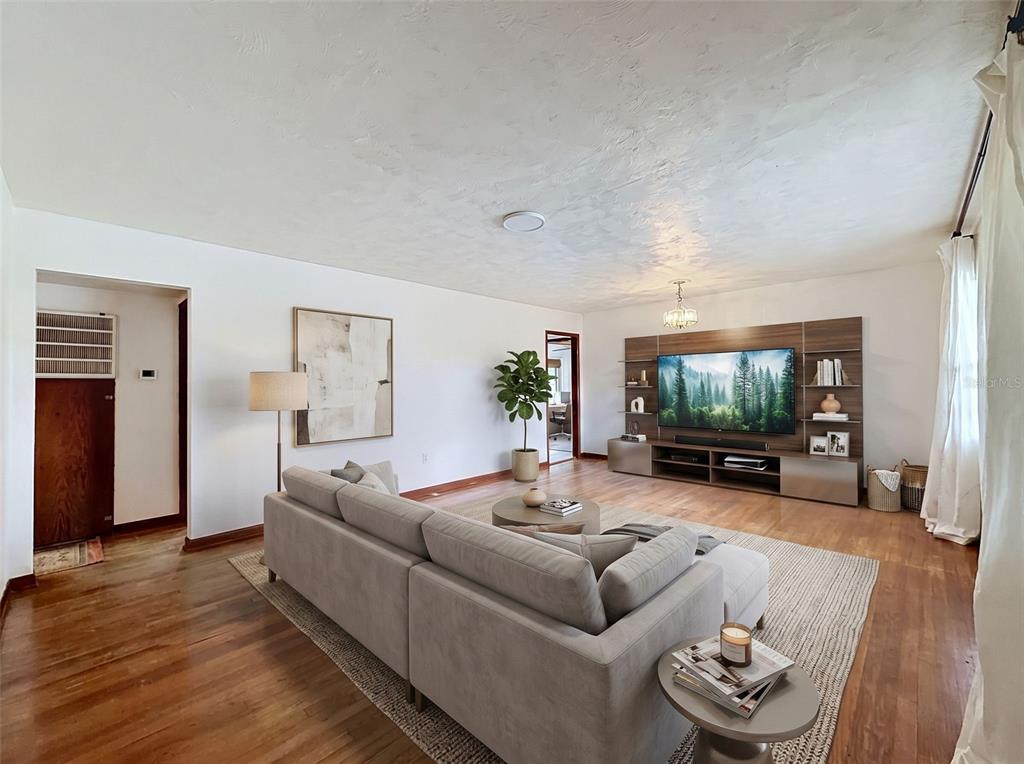 A living room features a sectional sofa, wood flooring, and a large wall-mounted media unit — 2518 W NORTH STREET, TAMPA, FL