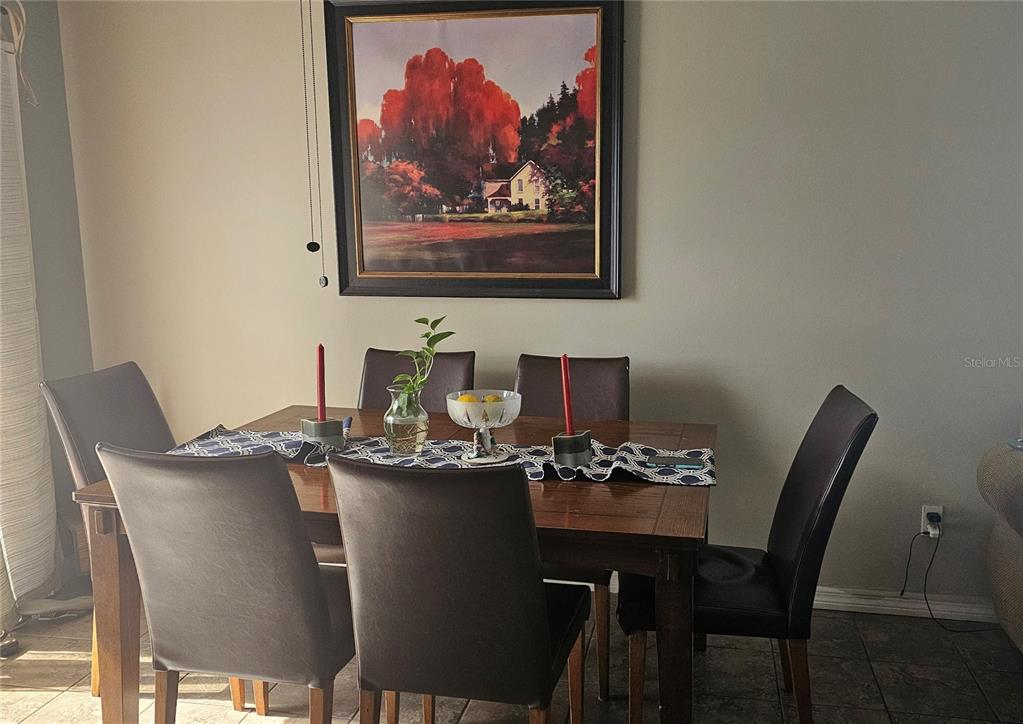 A dining room features a wooden table with six chairs and a framed landscape painting — 9906 SURREY RIDGE ROAD, ORLANDO, FL
