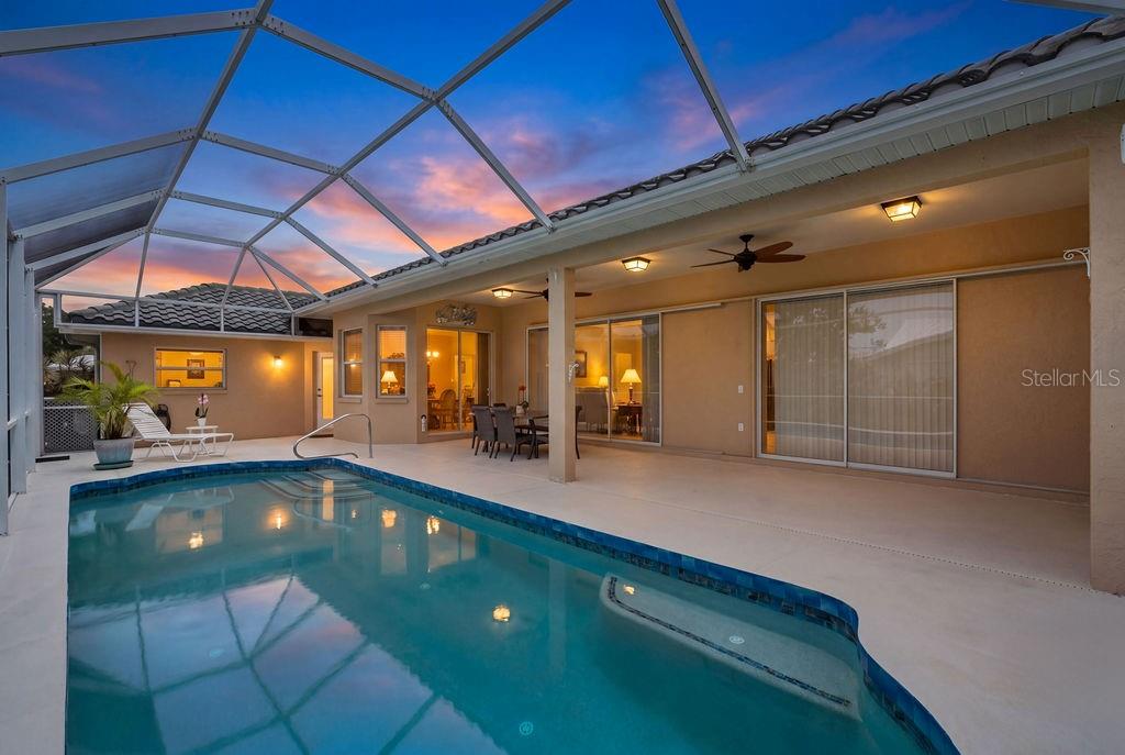 A screened-in patio features a swimming pool, outdoor dining area, and sliding glass doors — 1543 WATERFORD DRIVE, VENICE, FL