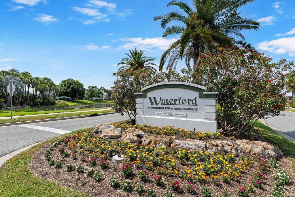 A sign for Waterford golf and tennis community stands in a landscaped garden bed — 1543 WATERFORD DRIVE, VENICE, FL
