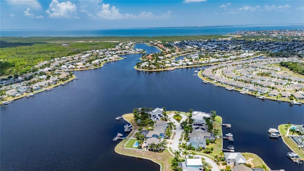 A vibrant orange sunset glows over a waterfront neighborhood with houses and a boat dock — 5216 POINT HARBOR LANE, APOLLO BEACH, FL