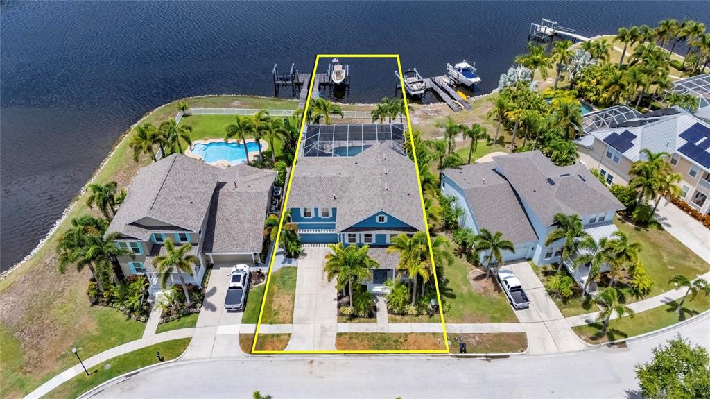 An aerial view shows waterfront houses with private docks along a large canal system — 5216 POINT HARBOR LANE, APOLLO BEACH, FL