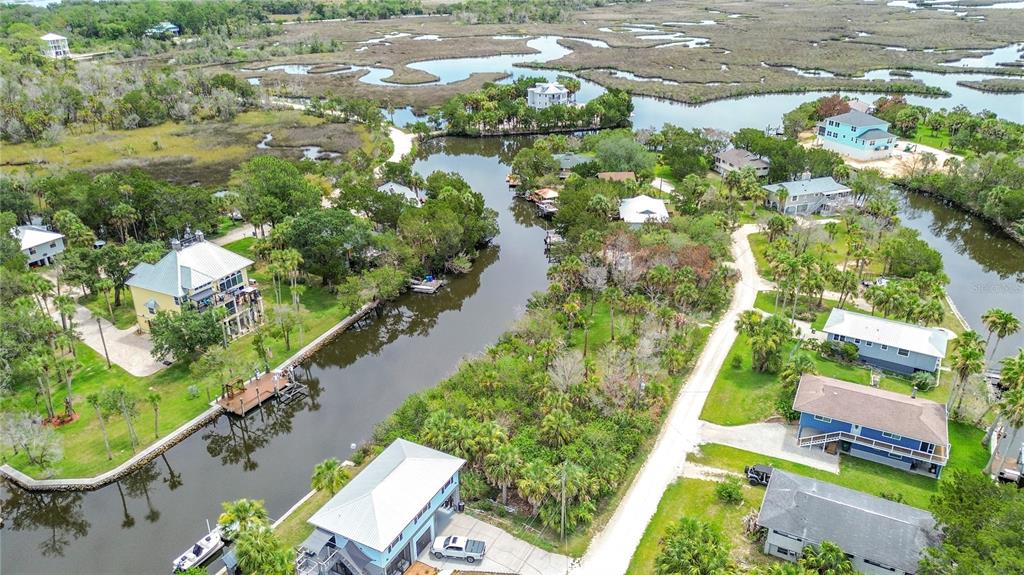 An aerial view shows houses situated along a canal winding through a coastal marshland — 12073 W GULF BREEZE COURT, CRYSTAL RIVER, FL