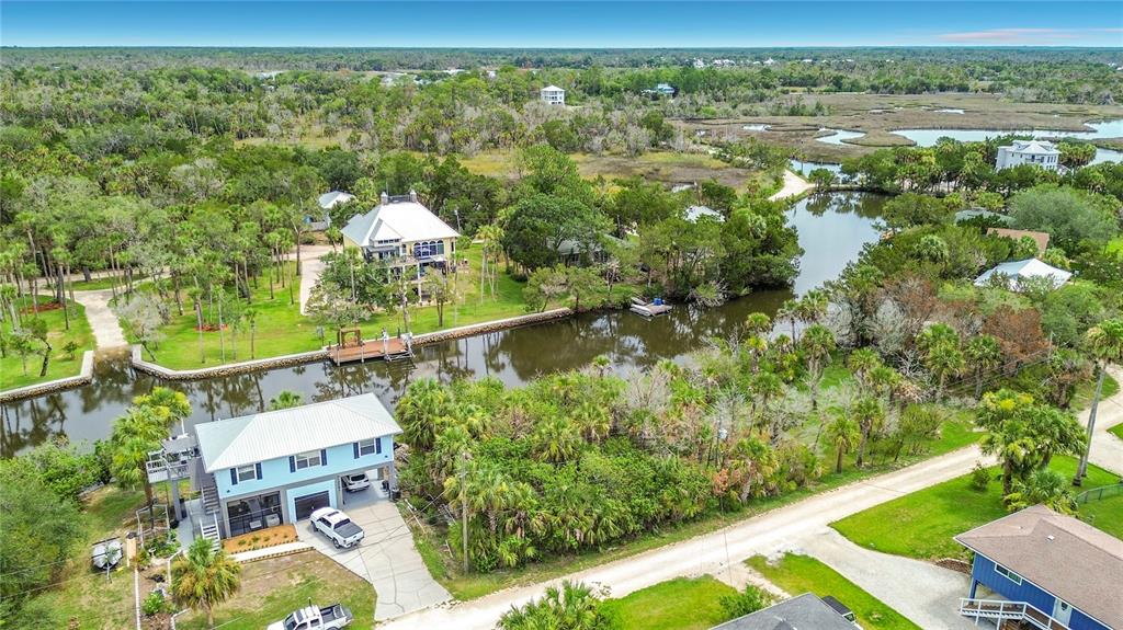 An aerial view shows houses along a canal surrounded by trees and marshland — 12073 W GULF BREEZE COURT, CRYSTAL RIVER, FL