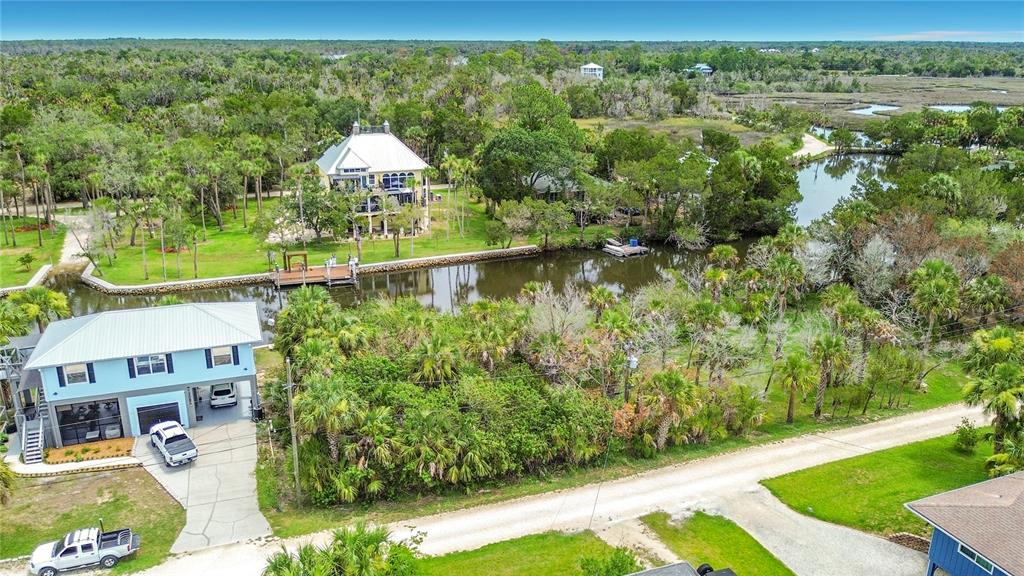 An aerial view shows two houses near a canal surrounded by trees and marshland — 12073 W GULF BREEZE COURT, CRYSTAL RIVER, FL
