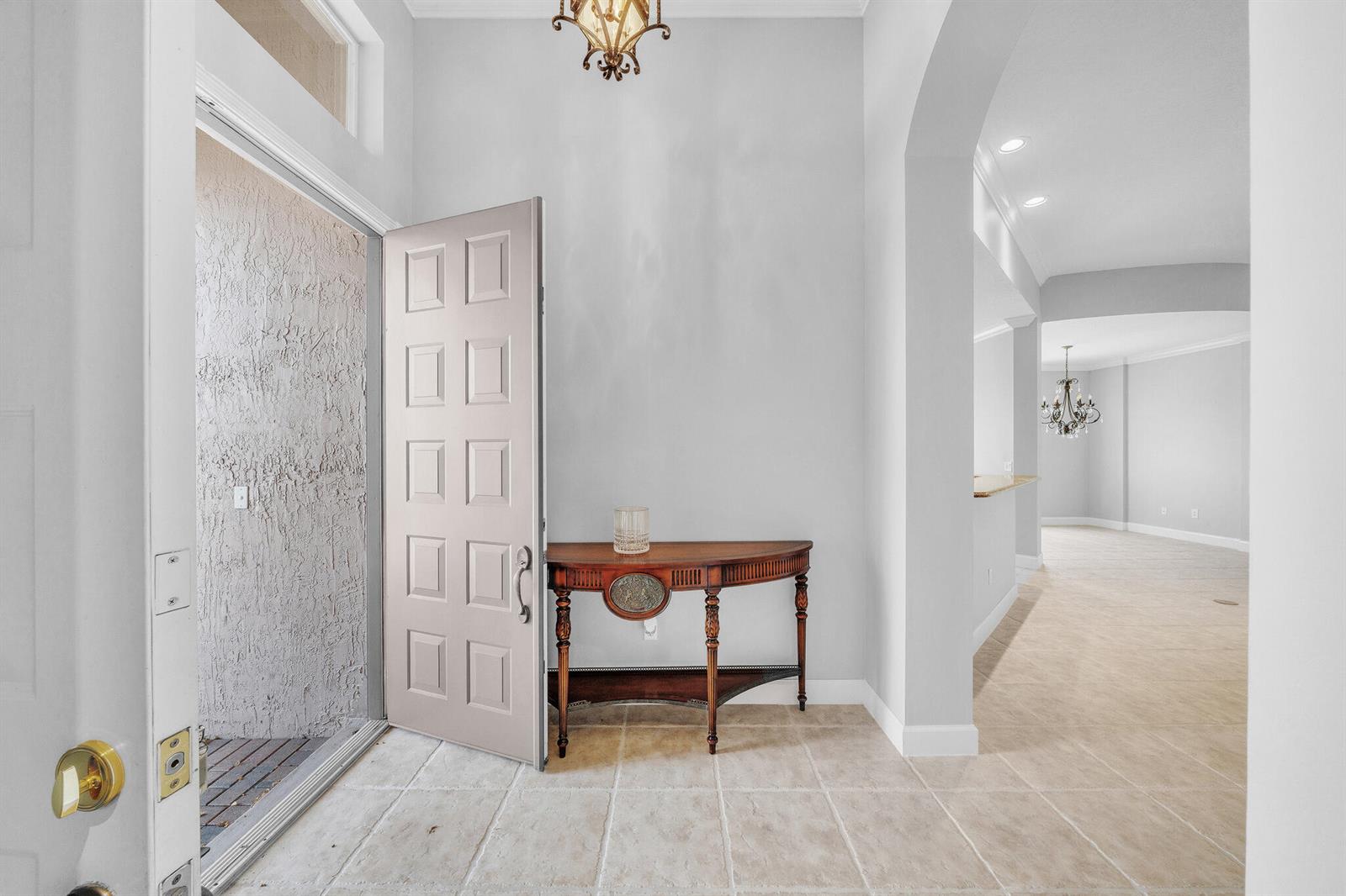 A foyer with tile flooring, a wooden console table, and an open doorway leading inside — 6581 Southport Drive, Boynton Beach FL 33472, BOYNTON BEACH, FL