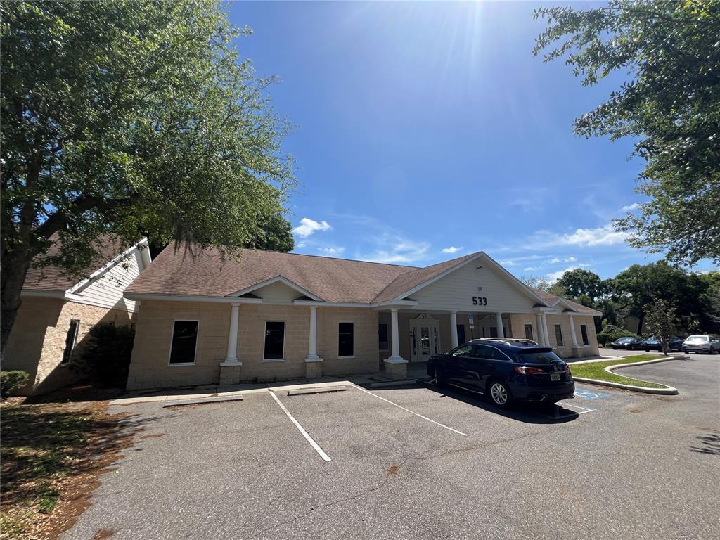 A single-story commercial building with a tan brick facade and a dark blue SUV parked outside — 533 MEDICAL OAKS AVENUE UNIT 3, BRANDON, FL