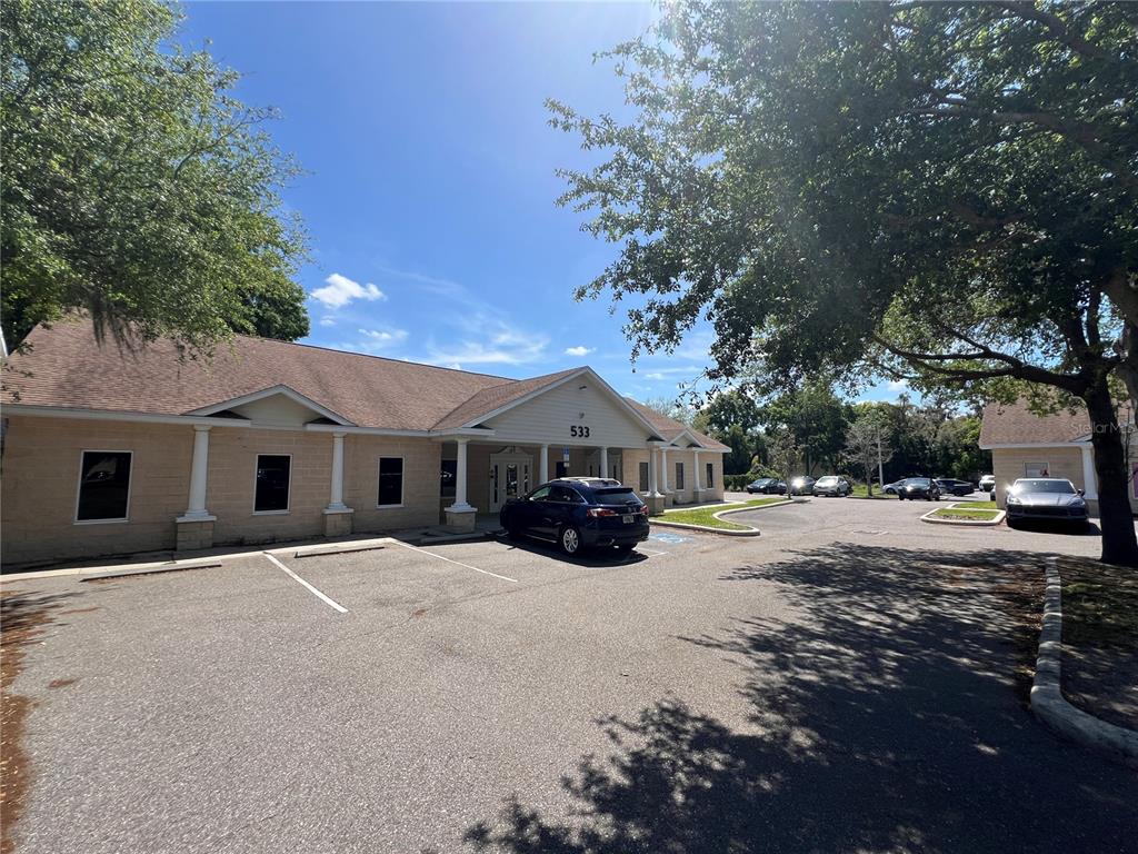 A single-story commercial building with a tan facade and parking lot under a blue sky — 533 MEDICAL OAKS AVENUE UNIT 3, BRANDON, FL