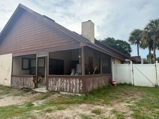 A house exterior features a screened-in porch with wood siding and a white vinyl fence — 2218 BARKWOOD COURT, LAKE MARY, FL