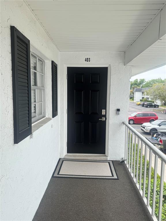A black front door with the number 403 sits on a covered balcony with railings — 102 46TH AVENUE TERRACE W UNIT 403, BRADENTON, FL