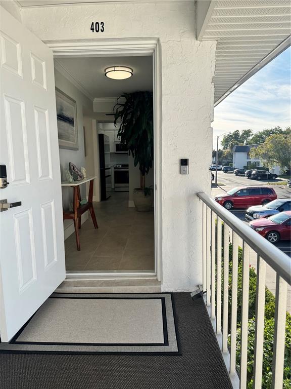 An open door reveals a tiled entryway with a console table and a large plant — 102 46TH AVENUE TERRACE W UNIT 403, BRADENTON, FL