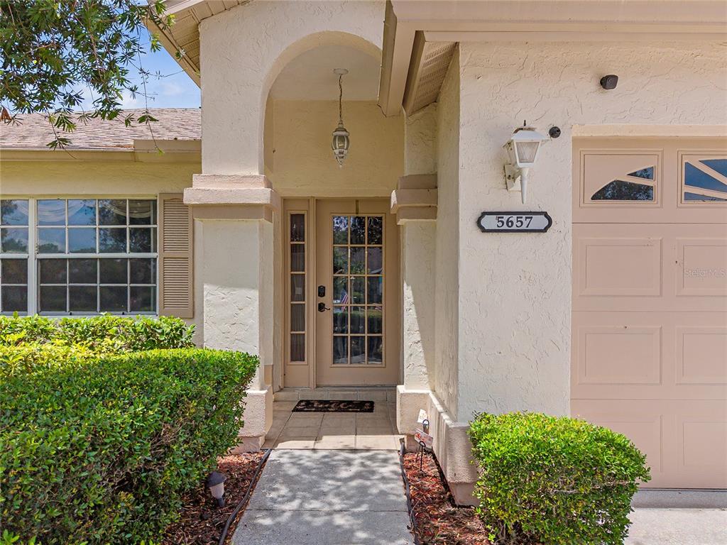 The exterior view shows a house entrance with a front door, walkway, and garage — 5657 29TH STREET CIRCLE E, BRADENTON, FL