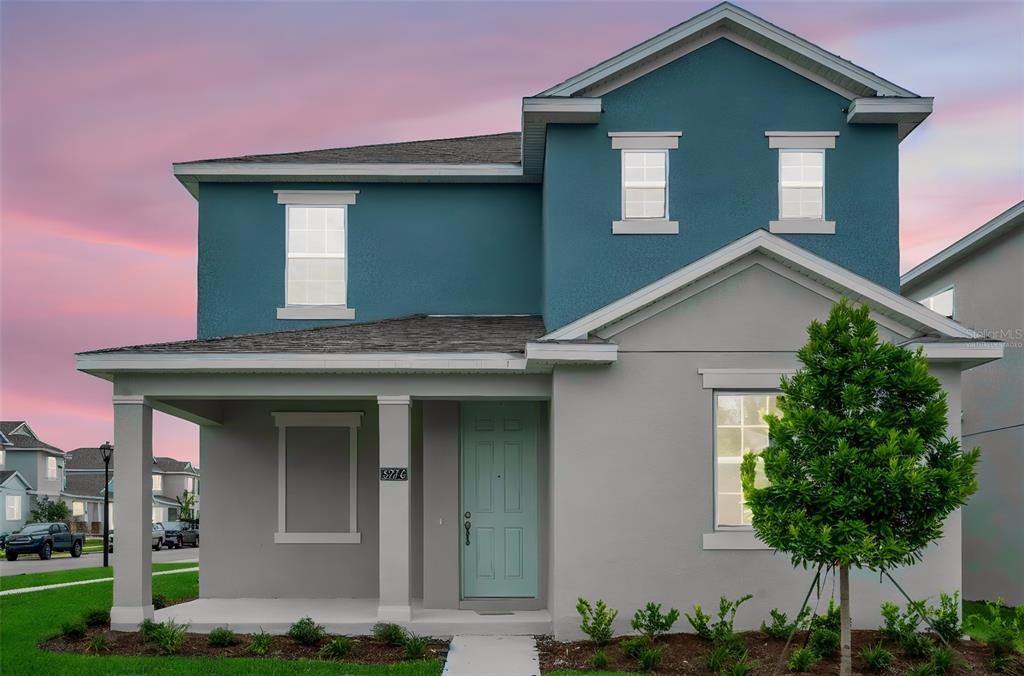 A two-story house with a blue and gray exterior, a front porch, and a small tree — 5137 BLANKET FLOWER STREET, APOPKA, FL