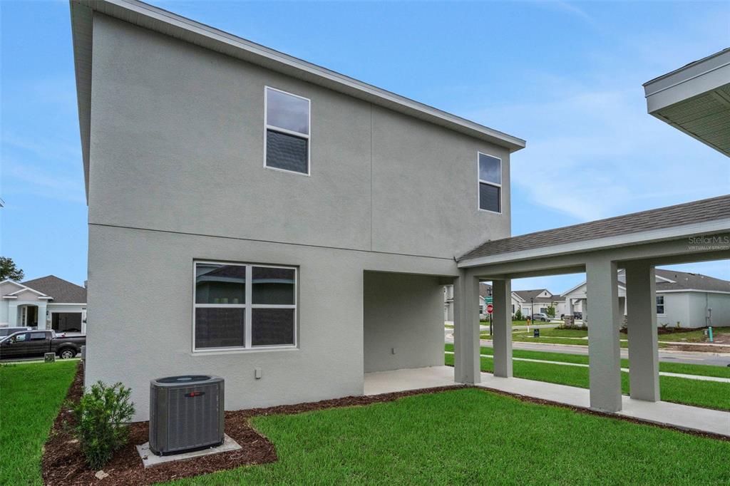 A two-story house exterior features a covered walkway, a ground-level patio, and an AC unit — 5137 BLANKET FLOWER STREET, APOPKA, FL
