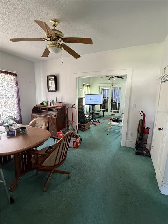A dining area with a wooden table and desk leads into a living room — 600 5TH AVENUE, DAYTONA BEACH, FL