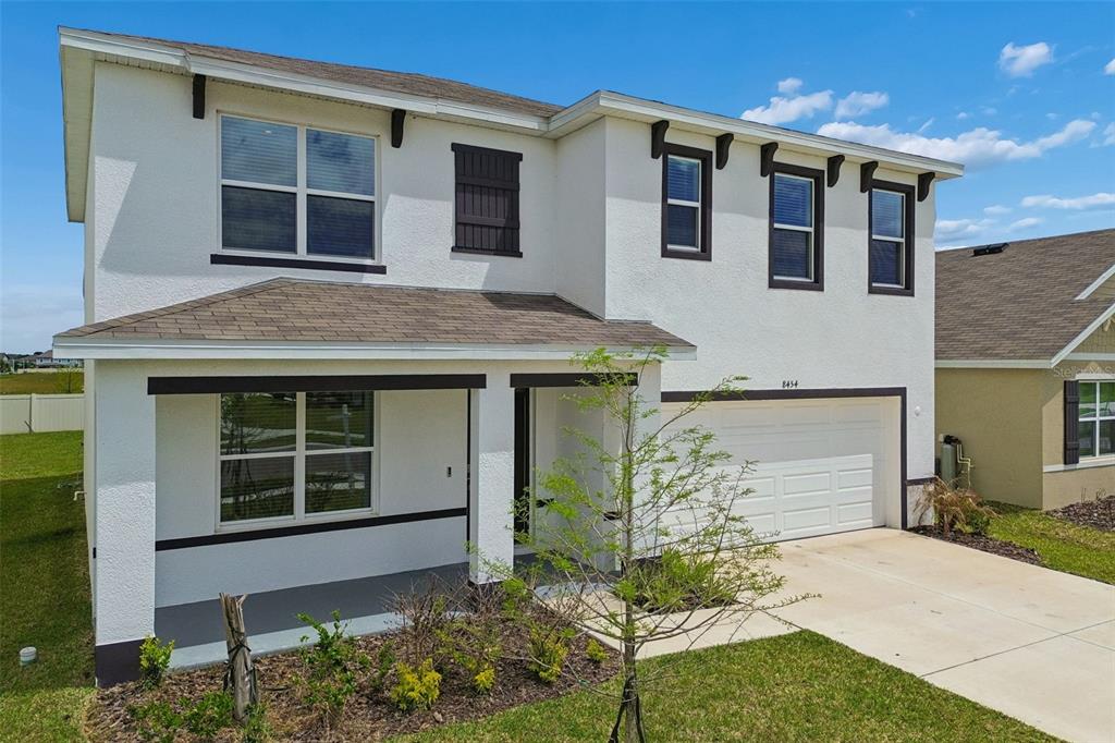 A two-story house with white stucco siding, a brown shingled roof, and a two-car garage — 8454 ENDER HILLS DRIVE, WESLEY CHAPEL, FL