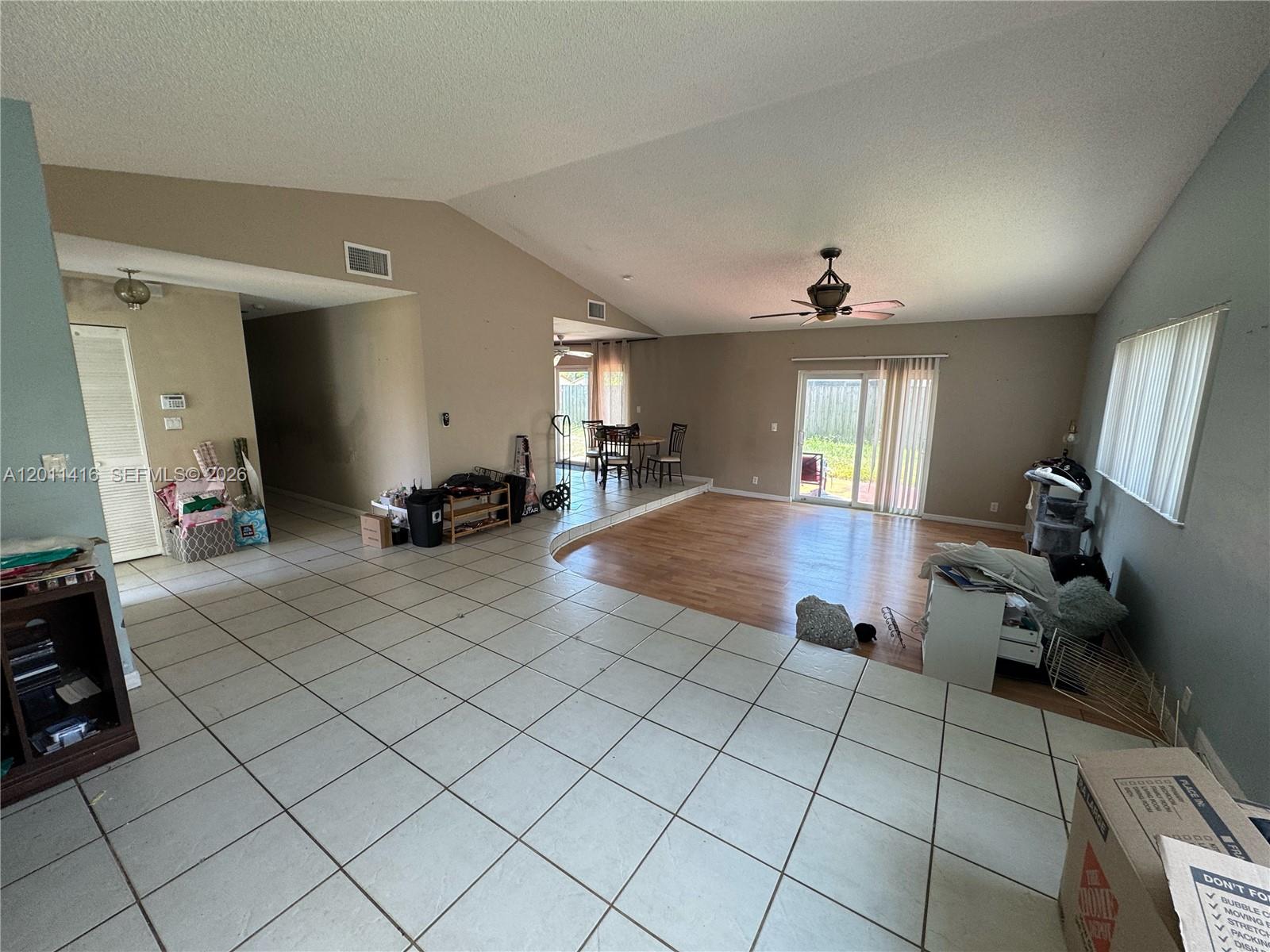 A living area features a sunken wood-floored space adjacent to a tiled floor section — 8700 NW 46th Ct, Lauderhill FL 33351, LAUDERHILL, FL