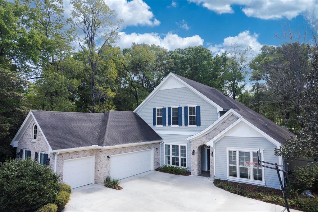 A two-story house with a brick and light blue siding exterior and a three-car garage — 10257 SW 37TH PLACE, GAINESVILLE, FL