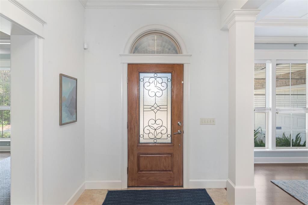 A foyer features a wooden front door with a glass insert and an arched transom window — 10257 SW 37TH PLACE, GAINESVILLE, FL
