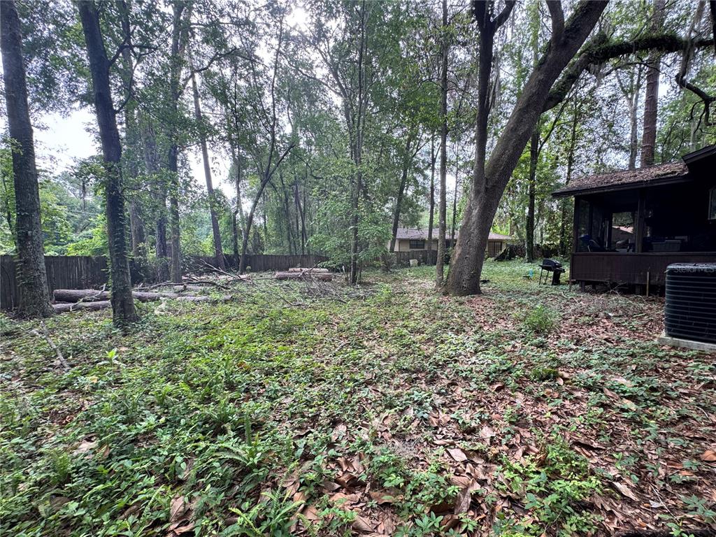 A brown wood-sided house with a brick base and a white front door — 713 NW 95TH TERRACE, GAINESVILLE, FL