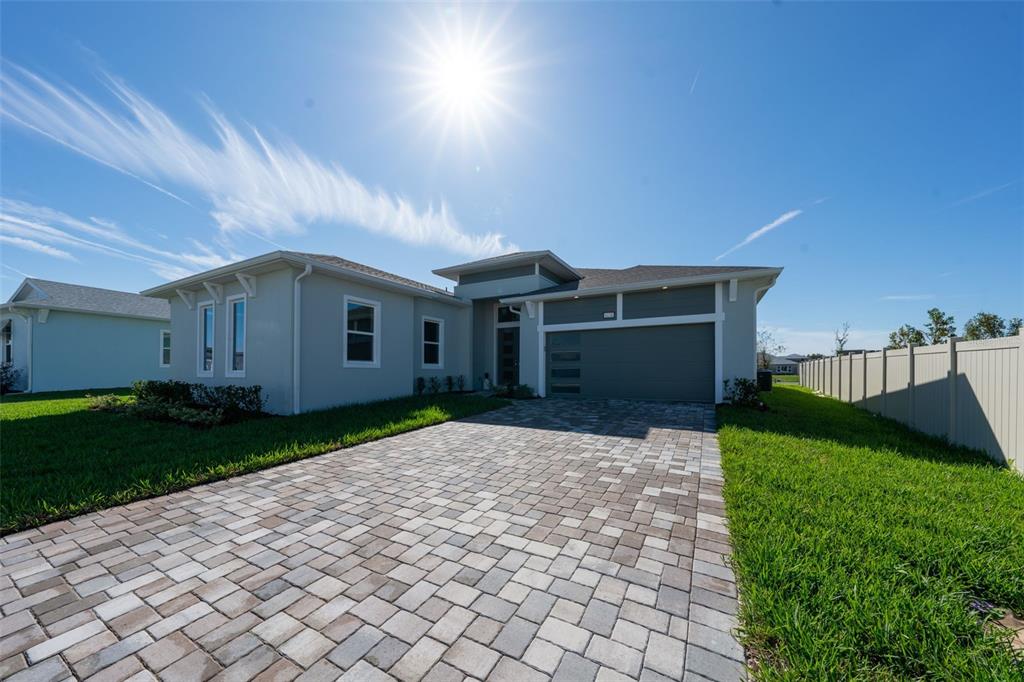 A single-story house with a paved driveway, gray exterior, and a two-car garage — 8178 IVY STARK BOULEVARD, WESLEY CHAPEL, FL